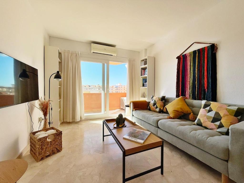 een woonkamer met een bank en een tafel bij Sunny & modern beach apartment in Fuengirola