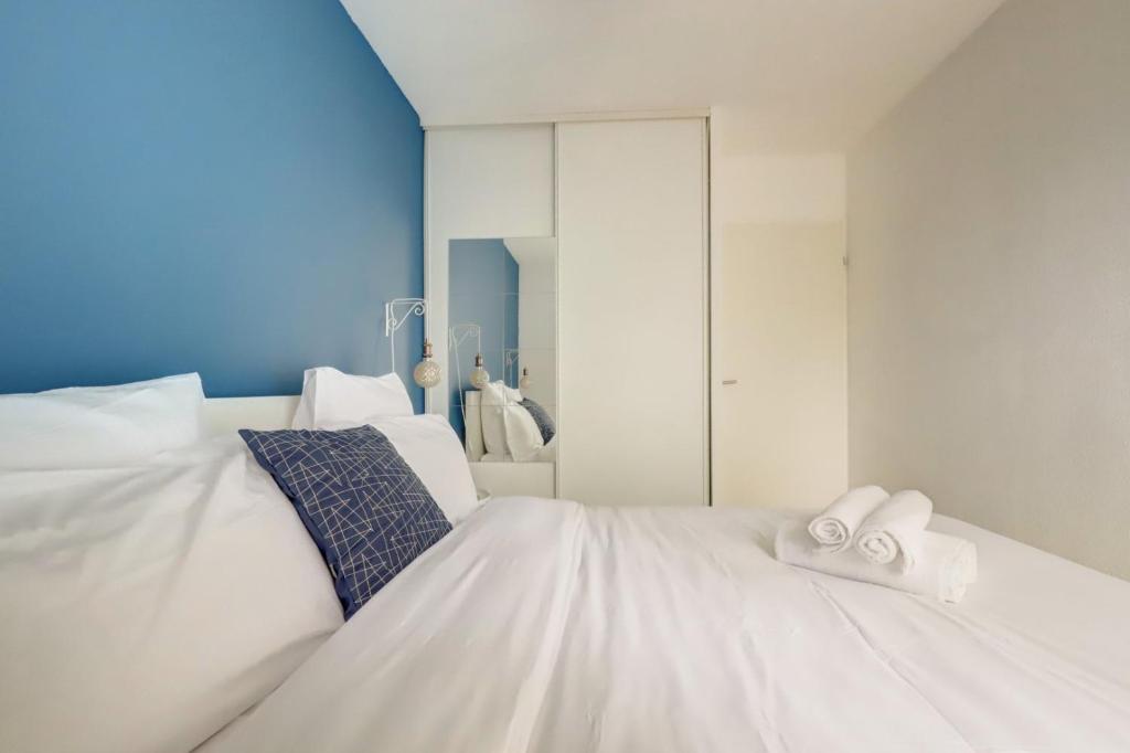 un lit blanc avec deux serviettes dessus dans l'établissement Le Bon Voyage ~ Terrasse ~ Parking ~ Basso Cambo, à Toulouse