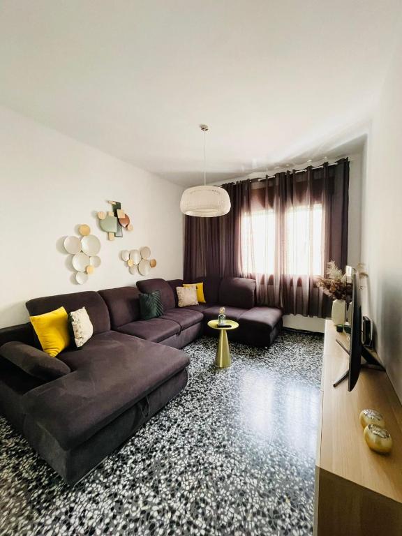 a living room with a brown couch and yellow pillows at Charment appartement a vinaros in Vinarós