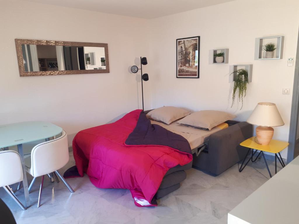 une chambre avec un lit, une table et un miroir dans l'établissement Joli Studio Cannes, à Cannes