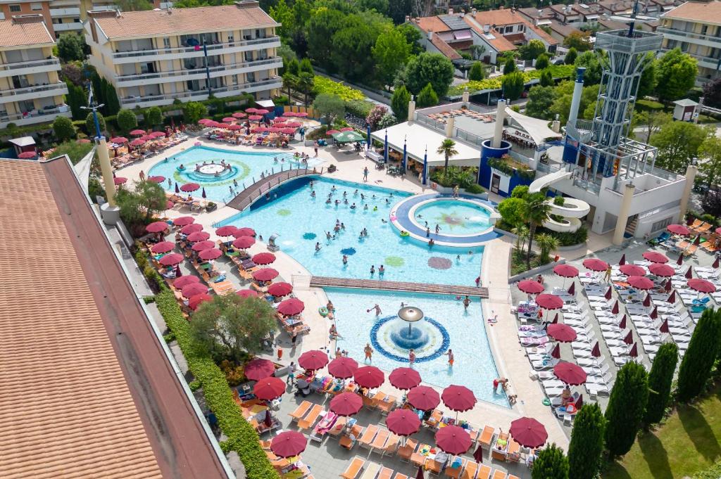 une vue aérienne d'une piscine de complexe hôtelier avec parasols et chaises dans l'établissement Villaggio Planetarium Resort, à Bibione