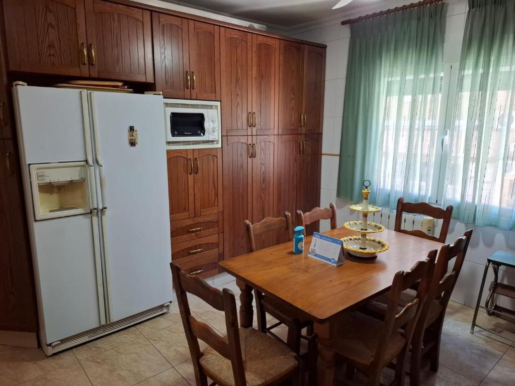 a kitchen with a table and a white refrigerator at Piso CONCEPCION in Hellín