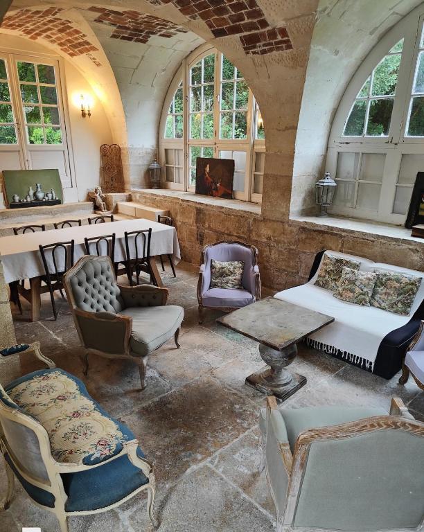 Cette chambre ancienne dispose de tables, de chaises et de fenêtres. dans l'établissement Orangerie du Saulce, à Escolives-Sainte-Camille