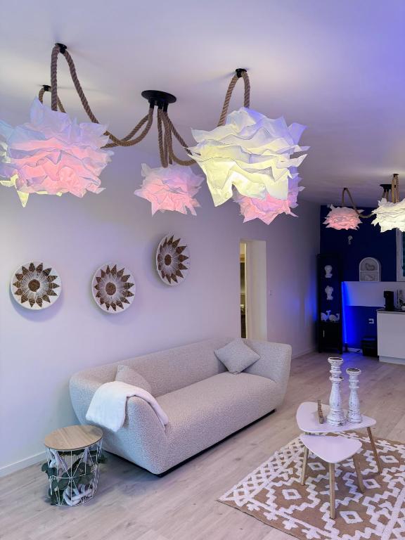 - un salon avec un canapé et quelques lumières dans l'établissement Appart Suite Balneo Jacuzzi Wifi Clim et Parking, à Mauguio