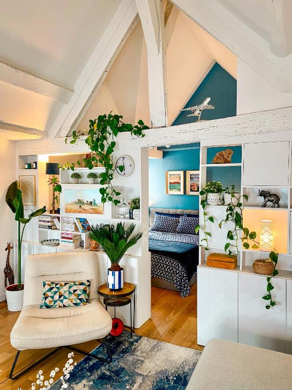 un salon avec un lit et une chaise dans l'établissement Le Marais Apartment Skylight Loft Escape, à Paris