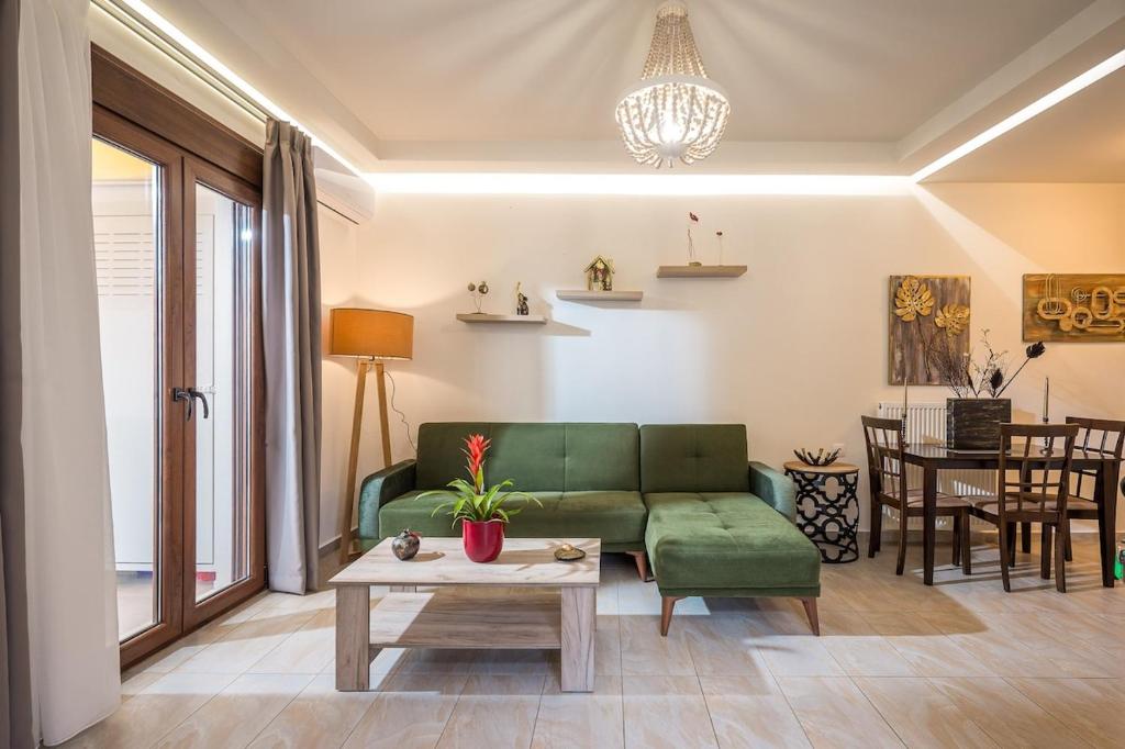 a living room with a green couch and a table at Archanes Philoxeno Appartment in the Village in Archanes