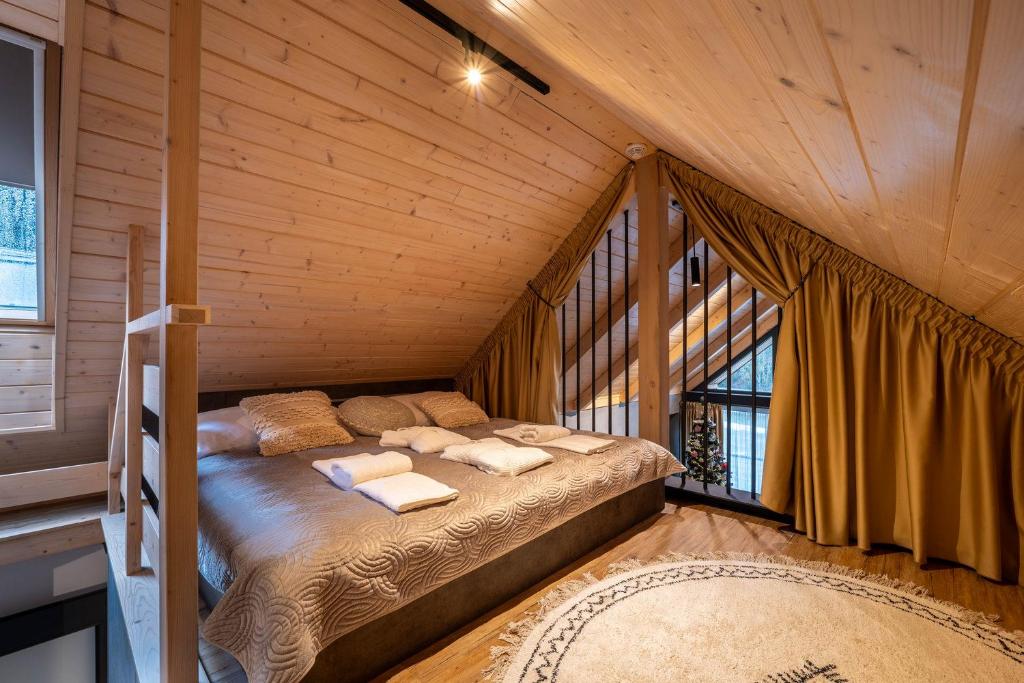 een slaapkamer met een bed in een houten kamer bij Chalet 4hills, Demänovská Dolina in Liptovský Mikuláš