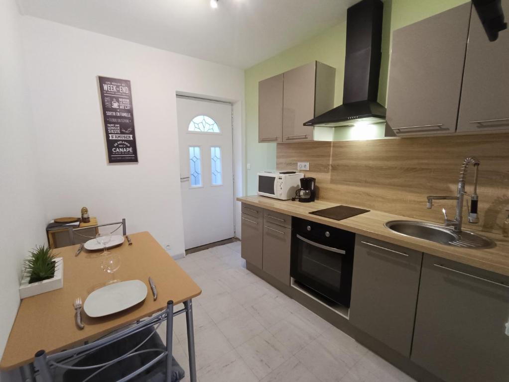 une cuisine avec un évier et un plan de travail dans l'établissement Appartement tout equipé à 600m du centre thermal, à Lamalou-les-Bains