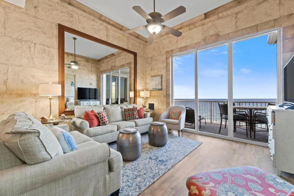 a living room with a couch and a large window at Spanish Key 705 in Perdido Key