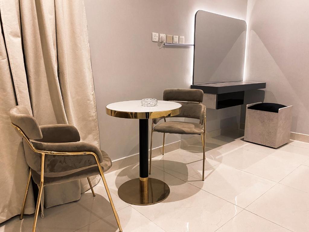 Una mesa y sillas en una habitación con televisión. en SKY2030Tower, en Dammam