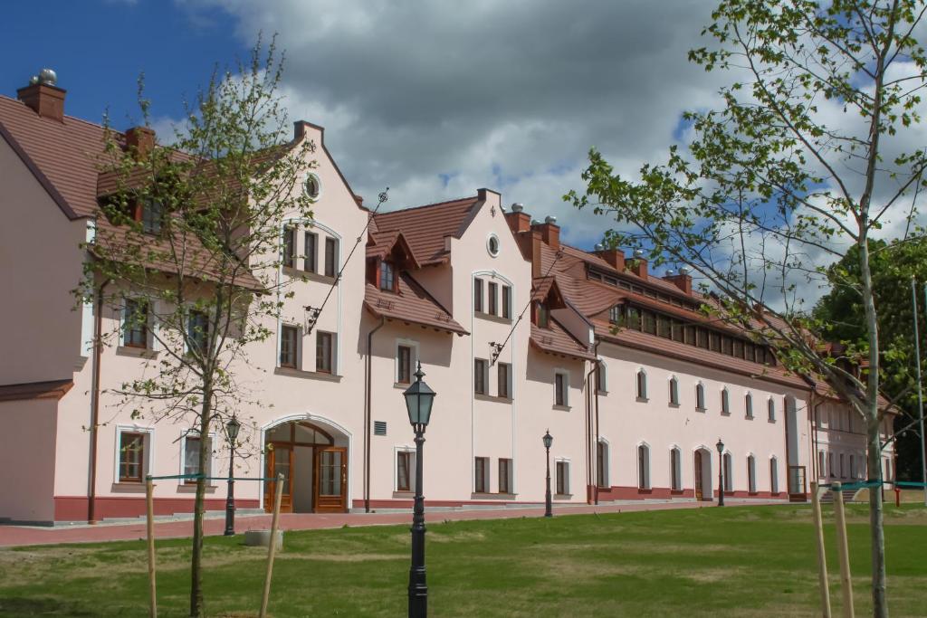 - un grand bâtiment blanc avec un éclairage de rue devant dans l'établissement Hotel Sulisław, à Sulisław