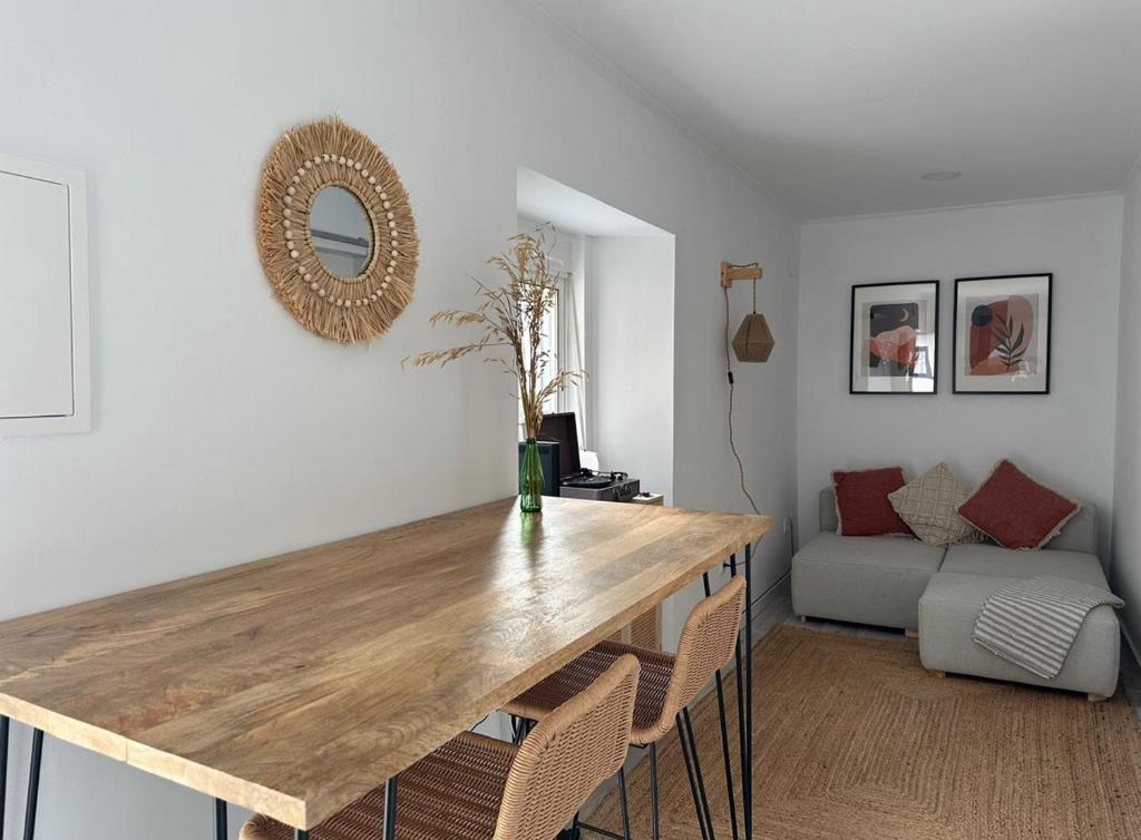a dining room with a wooden table and chairs at Casa da Aldeia in Alcácer do Sal