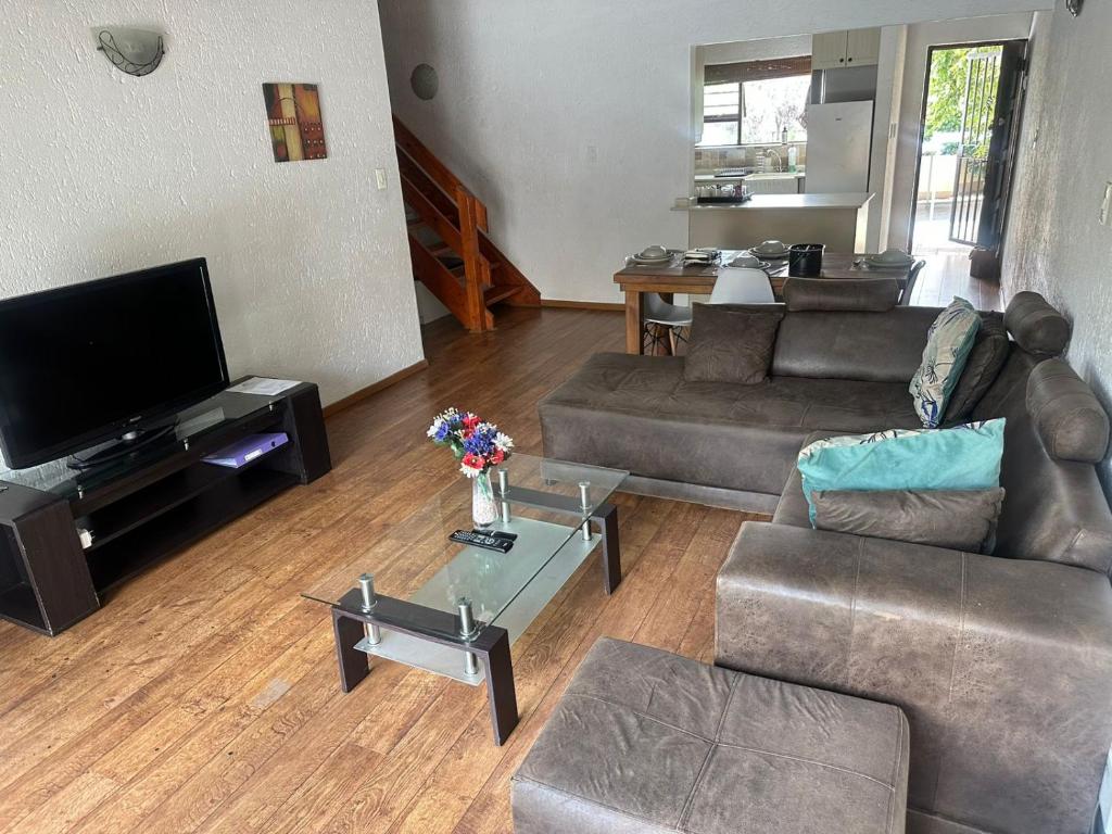 a living room with two couches and a tv at Paulshof Guesthouse - Monchique in Sandown