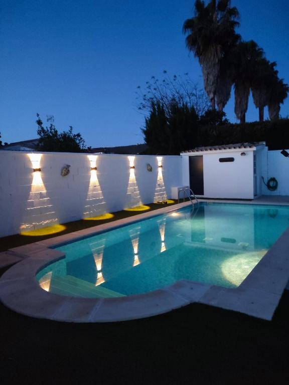 a swimming pool in front of a white fence at Villa Armonía in Arcos de la Frontera