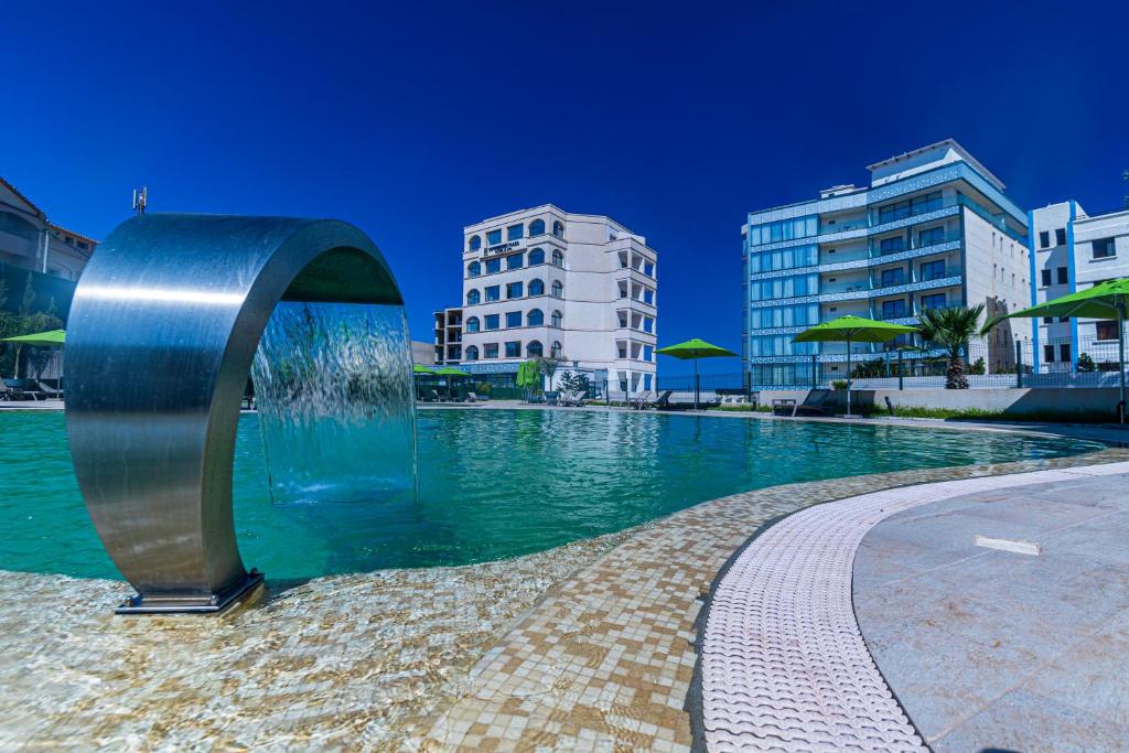 a fountain in the middle of a pool in a city at BOUMERDES PLAZA Hôtel & Spa in Boumerdes