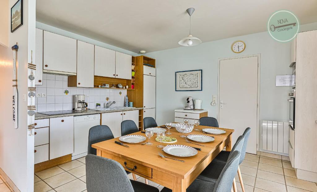 une cuisine et une salle à manger avec une table et des chaises en bois dans l'établissement Maison Oceane, à Saint-Hilaire-de-Riez