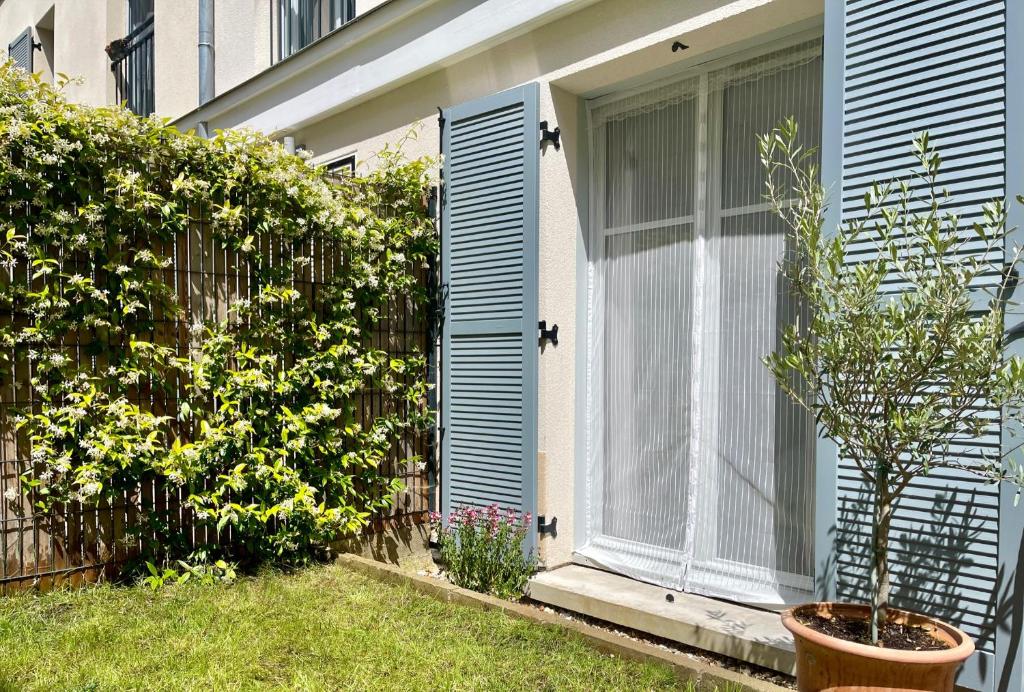 une maison avec une porte bleue et une clôture dans l'établissement Modern family 3 bedroom apartment in the center of Maisons-Laffitte, à Maisons-Laffitte
