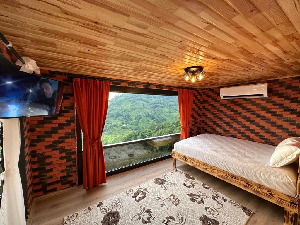 Un dormitorio con una cama y una ventana grande. en Bungalow, en Çamurlu