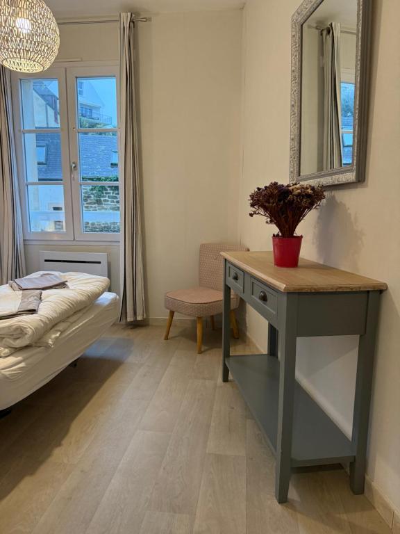 Pokój z łóżkiem, biurkiem i lustrem w obiekcie Appartement T2 vue sur la rivière avec garage privatif - Port de Saint-Goustan w mieście Auray