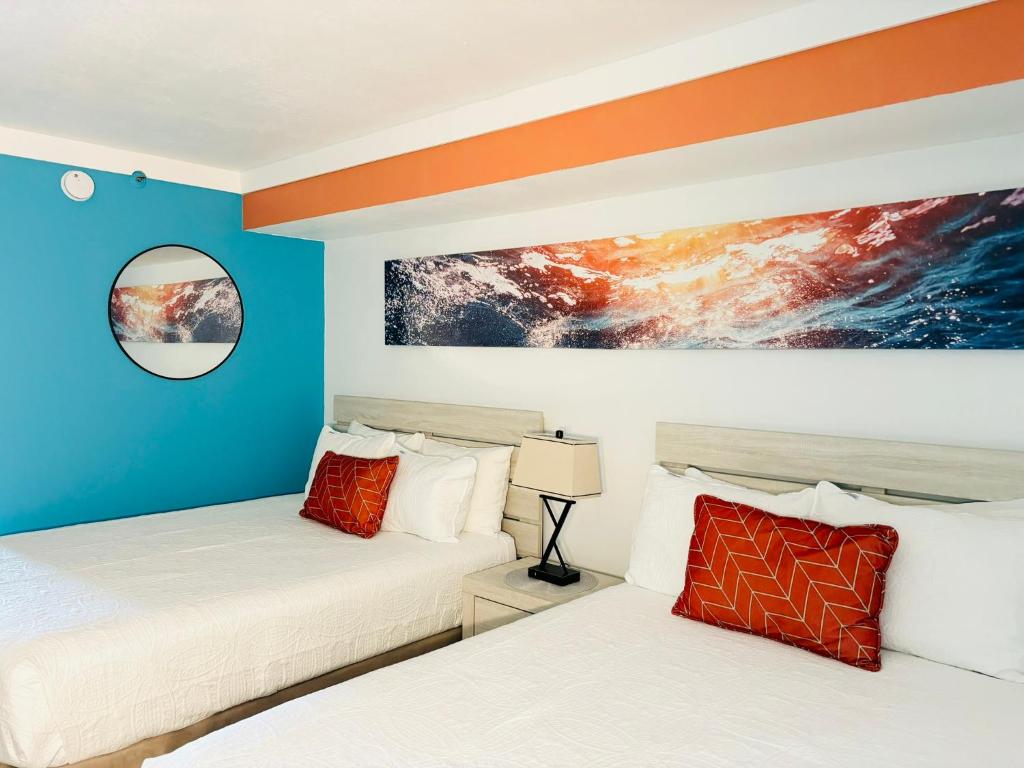 two beds in a room with blue and orange walls at 453 Shore Fun Oceanfront Great Location in Myrtle Beach
