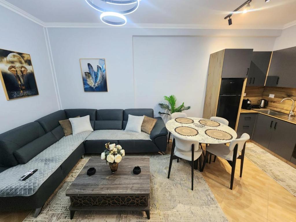 een woonkamer met een bank en een tafel bij Dior Apartment in Fier