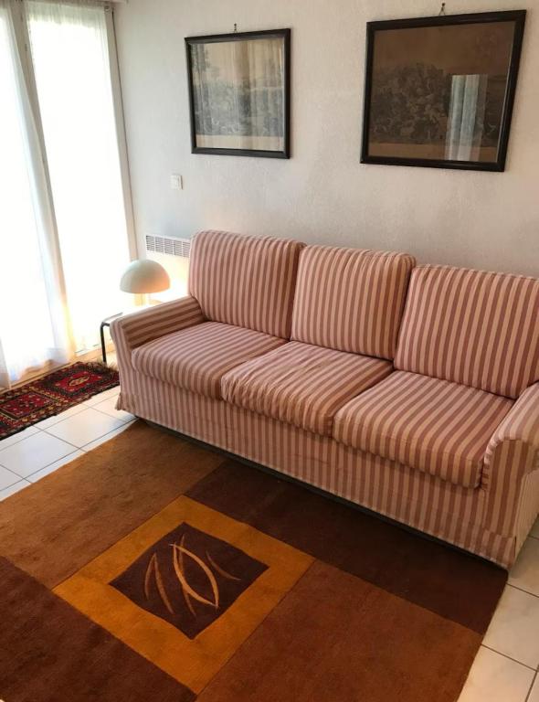 - un salon avec un canapé rayé dans l'établissement Appartement Le Port du Suquet, à Cannes