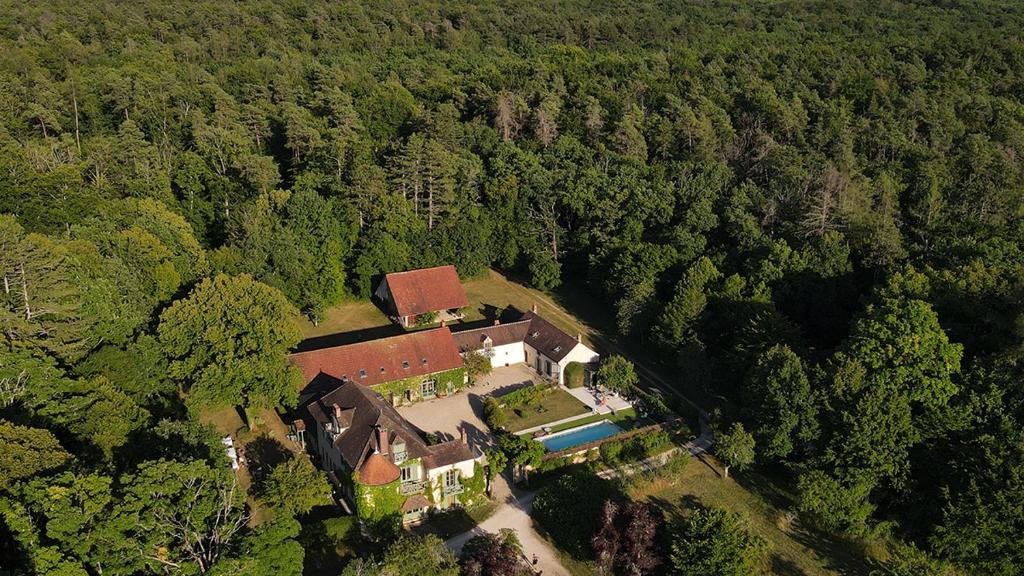 une vue aérienne d'une maison au milieu d'une forêt dans l'établissement Domaine de Sèche-Bouteille, à Étivey