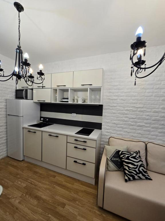 a living room with a couch and a chandelier at Апарамент за гости Романс Марин in Sunny Beach