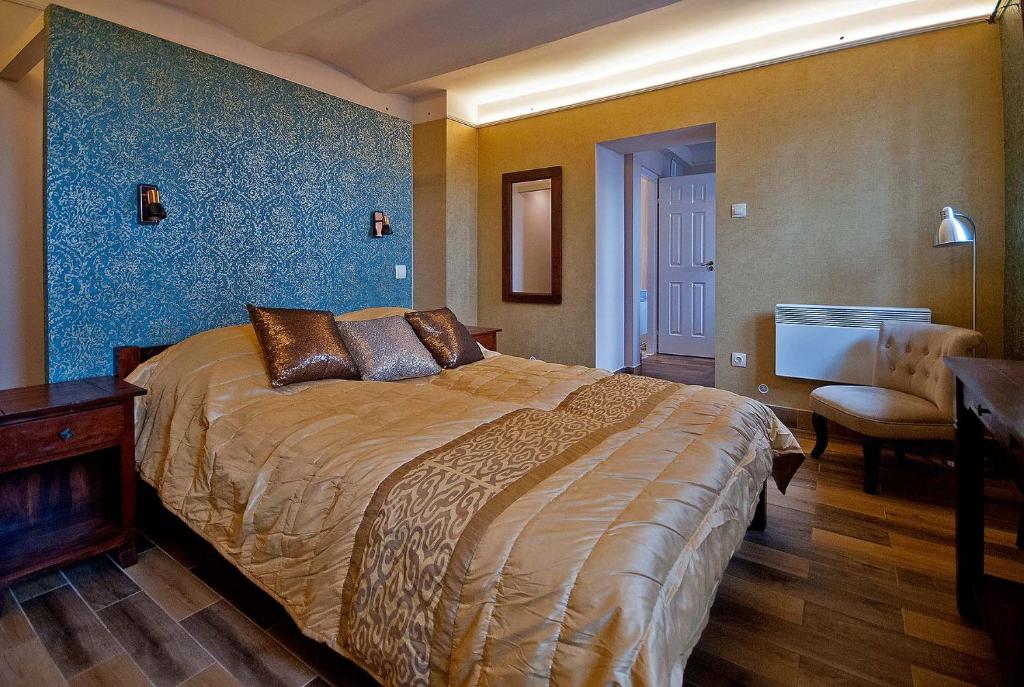 a bedroom with a large bed with a blue wall at Aradi Apartman in Pécs