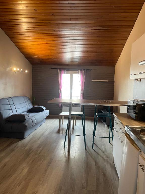 une cuisine et un salon avec une table et un canapé dans l'établissement Studio Périgueux 2ème étage, à Périgueux