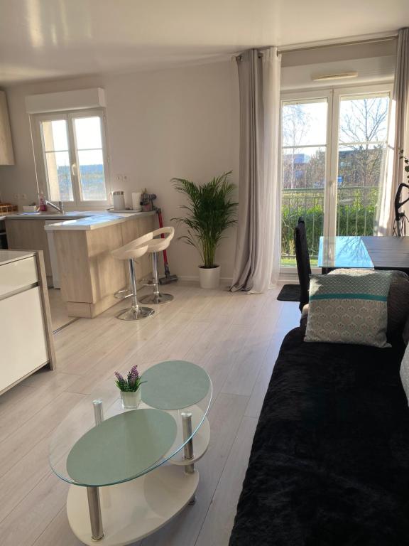 un salon avec un canapé et une table dans l'établissement Appartement Propre et Paisible Confort et Sérénité Assurés, à Moissy-Cramayel