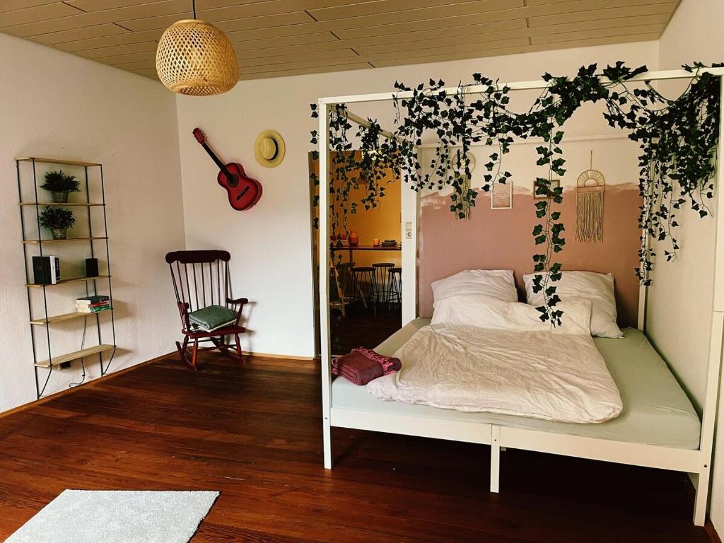Un dormitorio con una cama blanca con hiedra encima. en Zentrale gemütliche Wohnung Nähe Bahnhof, en Schwäbisch Hall