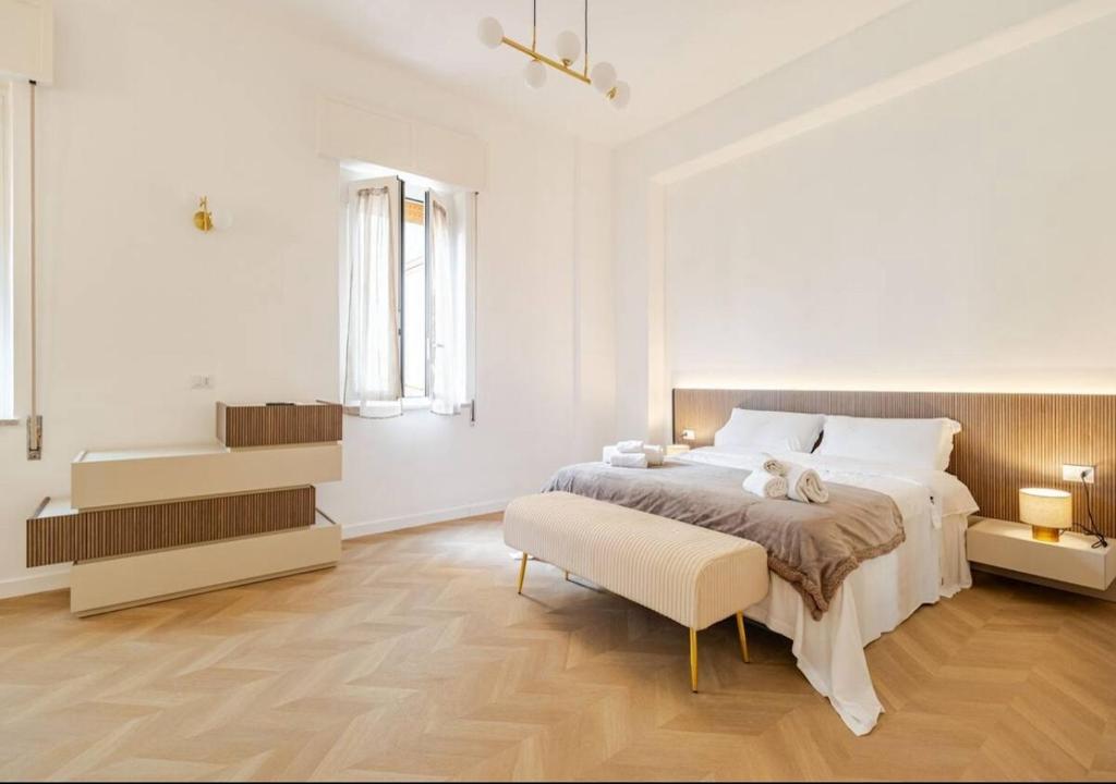 a white bedroom with a large bed and a chair at Residenza Camillo - Palermo Centro in Palermo