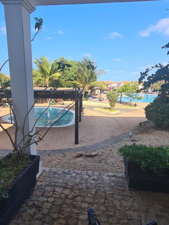 a view of the beach from the porch of a resort at Unique Poolside Apartment in Santa Maria