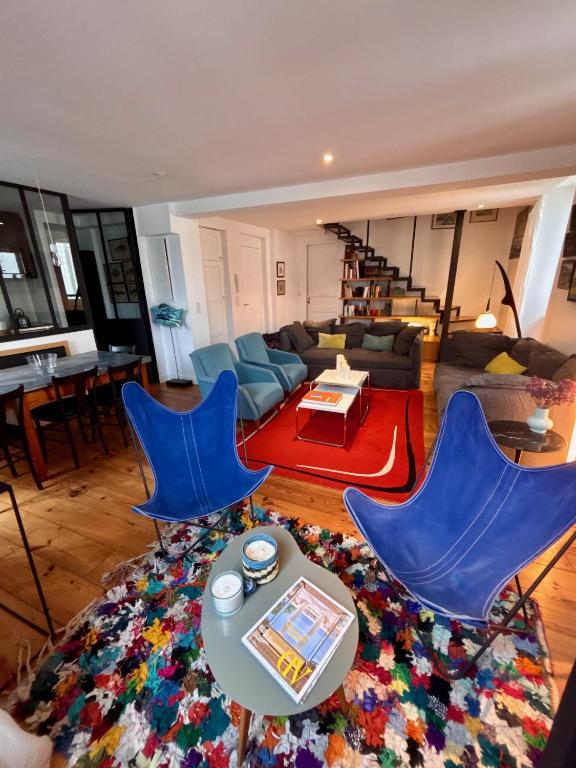 un salon avec deux chaises bleues et une table dans l'établissement Duplex T5 au pied de la plage, à Saint-Jean-de-Luz