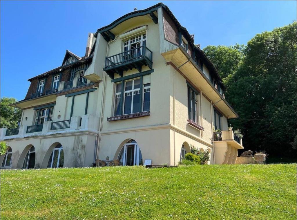 une grande maison au-dessus d'un champ verdoyant dans l'établissement Logement entier dans manoir à Trouville vue mer, à Trouville-sur-Mer