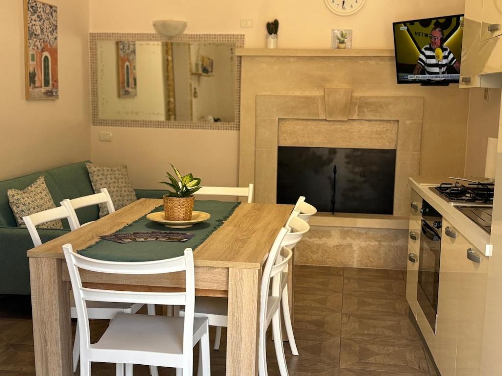 a kitchen and dining room with a wooden table and chairs at La casa di Martina - Antica dimora vista castello in Parabita