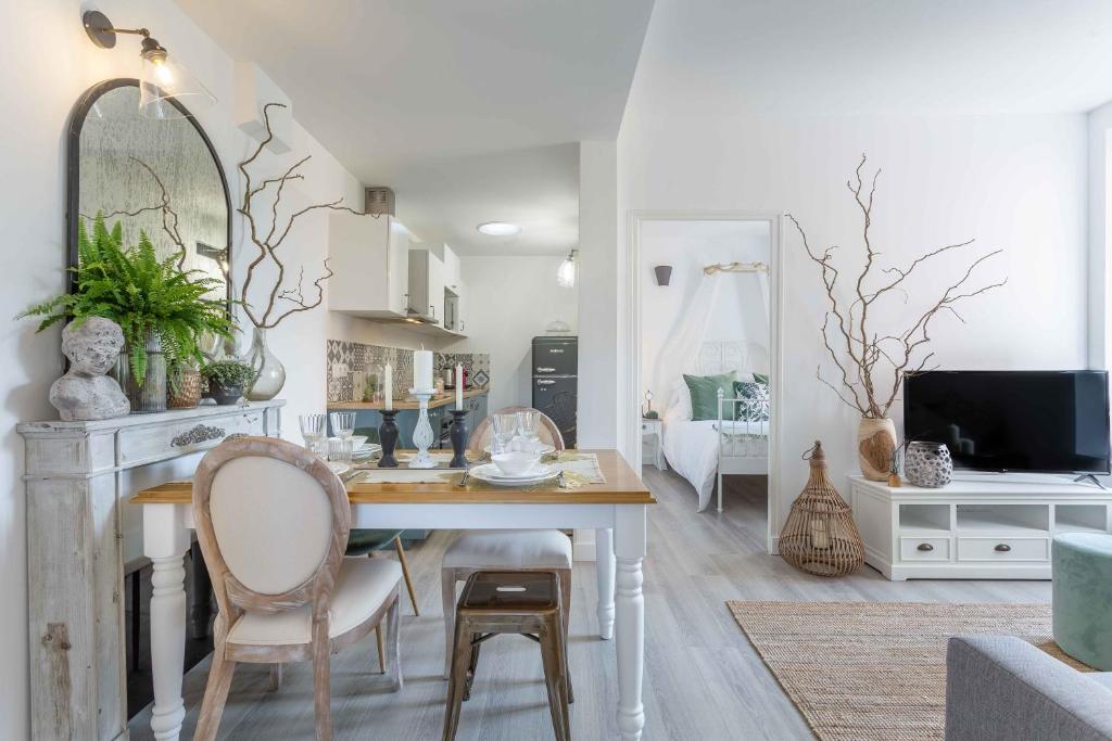 - un salon avec une table, des chaises et une télévision dans l'établissement Le Bel Ombre, à Lyon