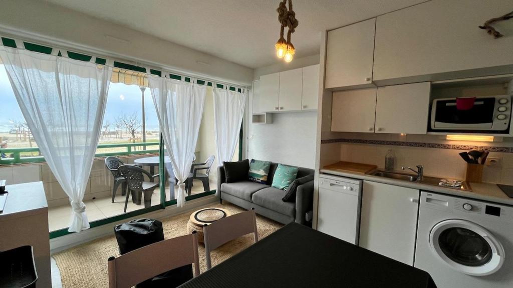 une cuisine et un salon avec un canapé et une table dans l'établissement La baïne, à Mimizan-Plage