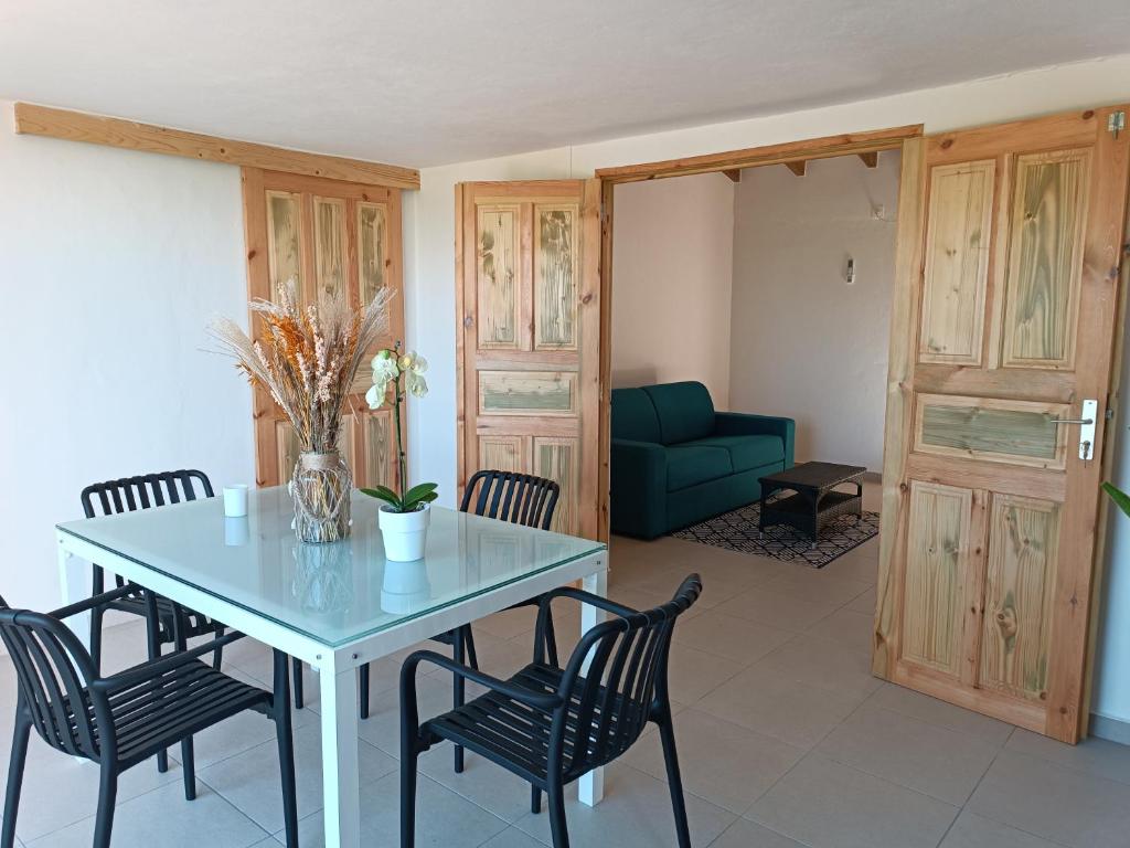 a dining room with a table and chairs and a couch at Maison de vacances à Deshaies 971 in Deshaies