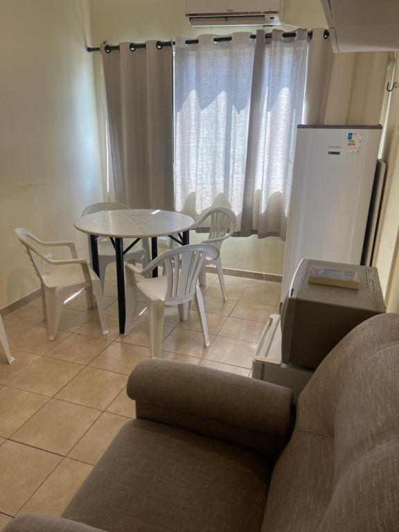 una sala de estar con un sofá, una mesa y sillas en BrunoApartamentos Recife - Derby Boa Vista - Apt 206, en Recife