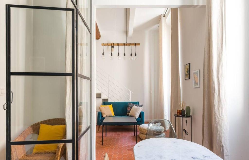un salon avec une chaise bleue et un miroir dans l'établissement Appartement authentique au centre d'Antibes, à Antibes
