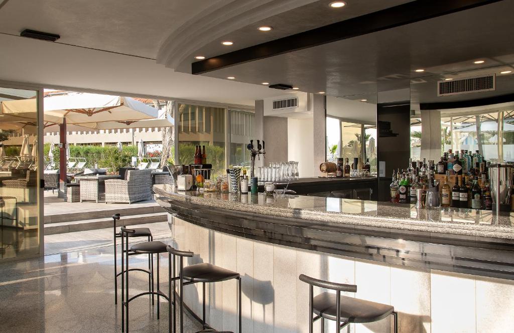 a bar in a restaurant with stools at Fantinello Hotel in Caorle
