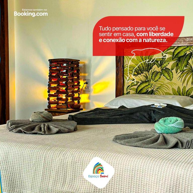 a sign on a bed with two towels on it at Espaço Sairé - 8 minutos da Praia in Alter do Chao