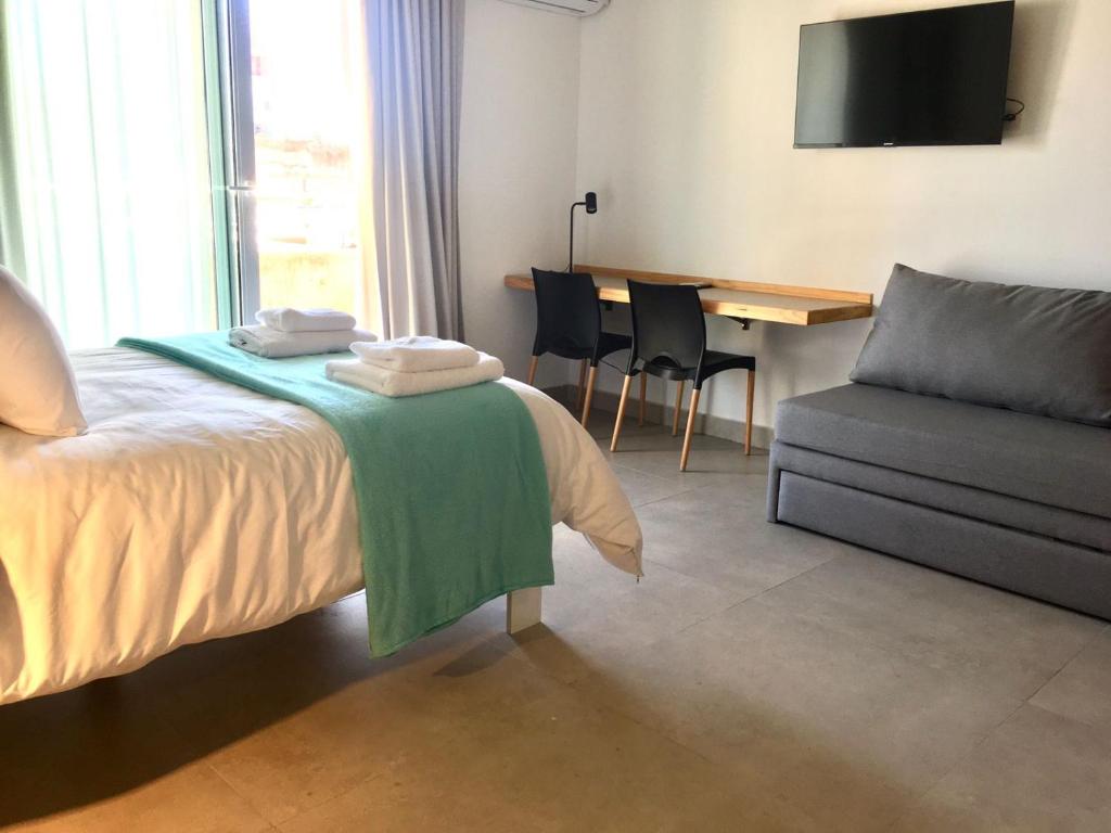 Una habitación de hotel con una cama, una mesa y un sofá. en Turquoise Buenos Aires, en Buenos Aires