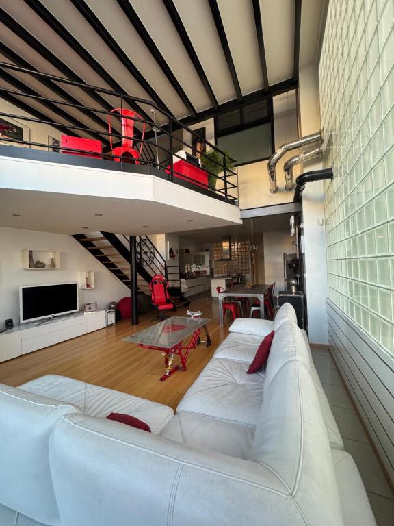 un salon avec un canapé blanc et une mezzanine dans l'établissement Loft design chez Lili aux portes de Paris, à Bagnolet