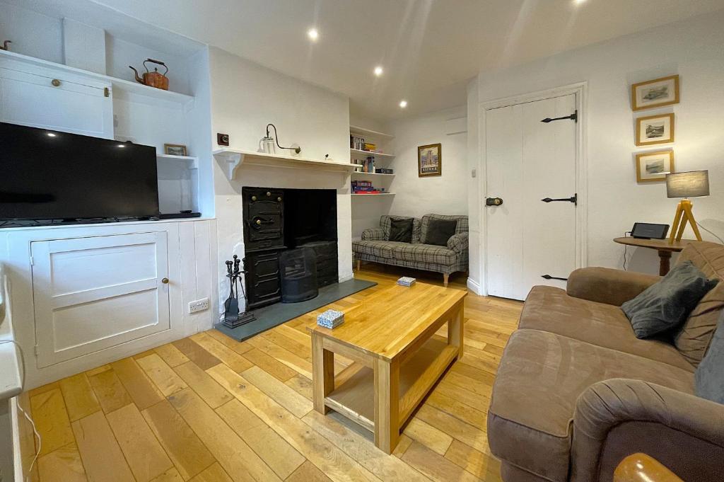 a living room with a couch and a fireplace at Barf Cottage in Portinscale