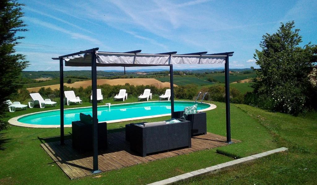 une piscine avec des chaises et un gazebo dans l'établissement Argein, à Villautou