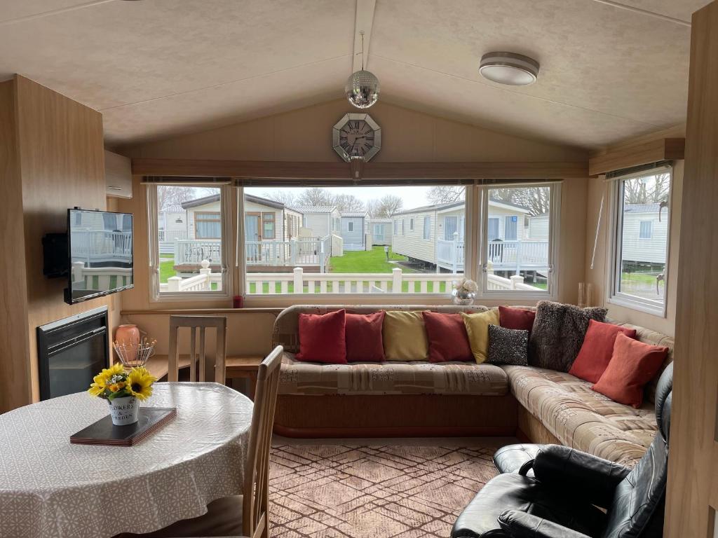 una sala de estar con un sofá y una mesa en Cosy 3 Bedroom Caravan, South Cerney, en South Cerney