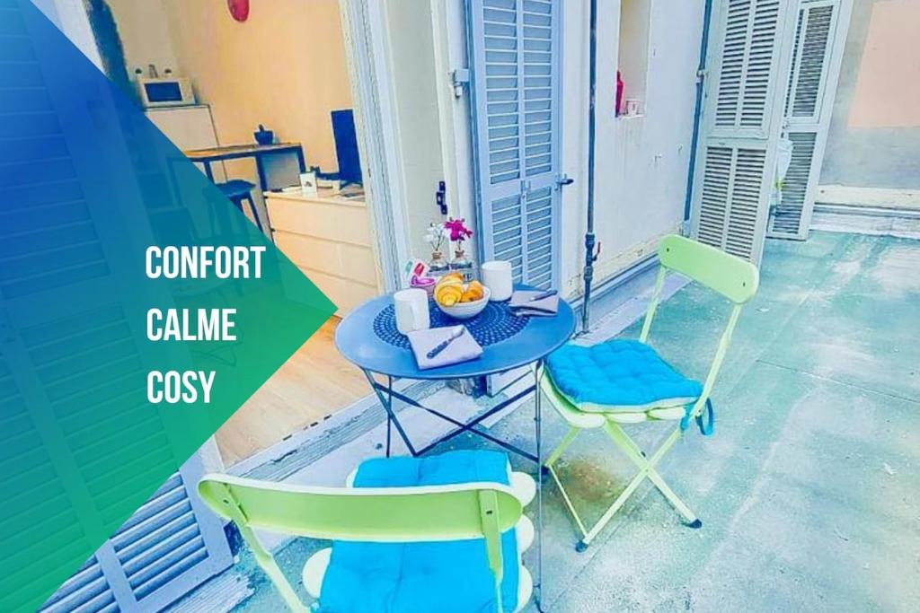 - une table avec deux chaises et une table avec un bol de fruits dans l'établissement Studio T1 Centre - Idéal couple & amis - Confort - WIFI - Calme - Climatisation - Coin Terrasse, à Nice